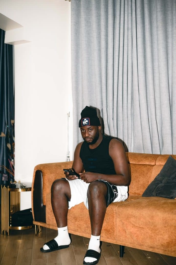Woriidem on a sofa, phone in hand, in a quiet room